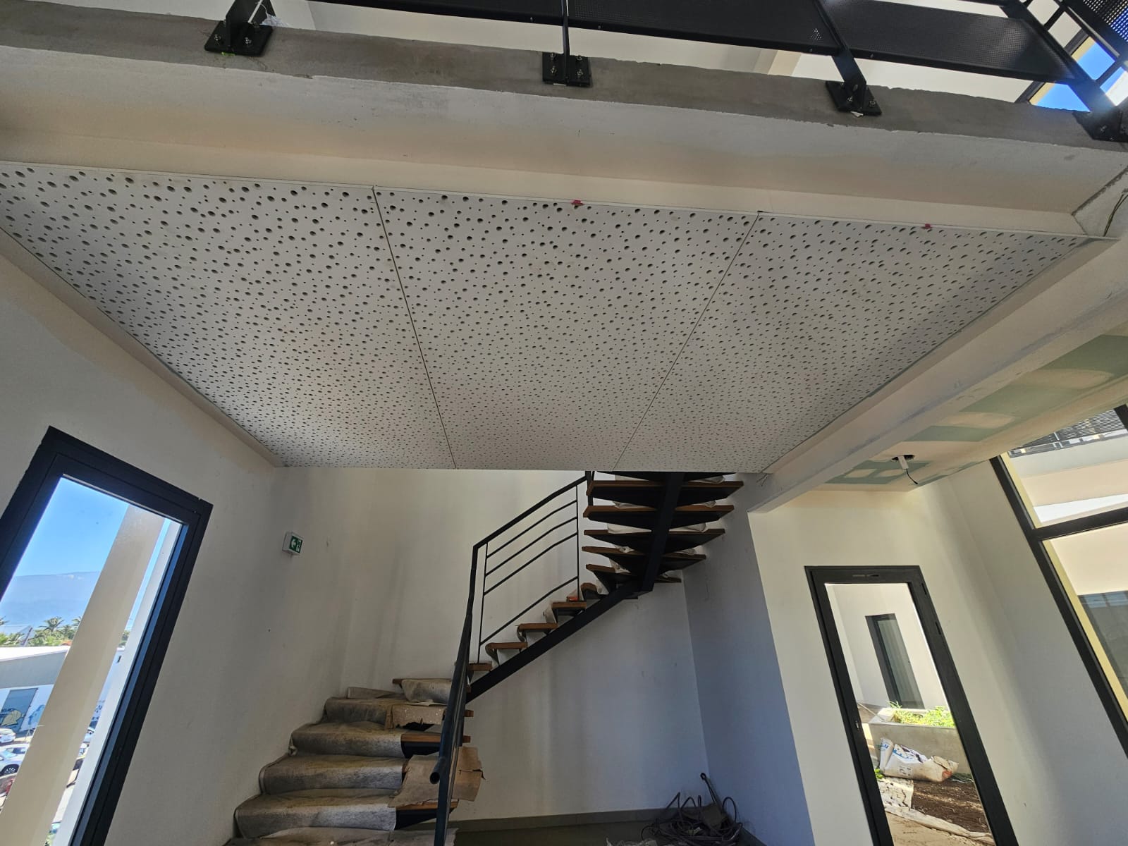 Hall avec plafond acoustique perforé